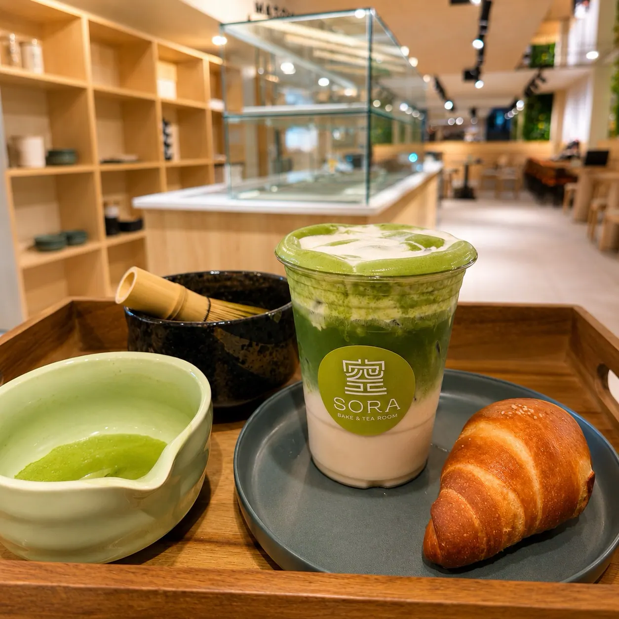 Iced matcha latte, salt bread, and traditional matcha tools at Sora Bake & Tea Room in Calgary