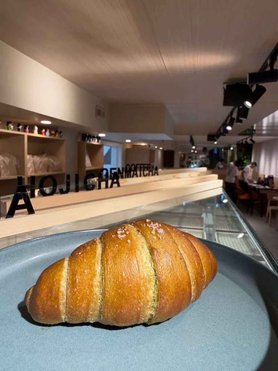 Freshly baked salt bread (shio pan) at Sora with hojicha, genmaicha, and coffee signage